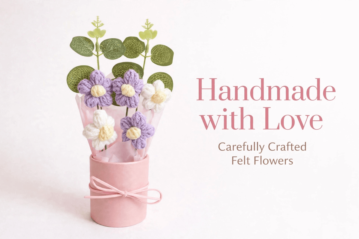 Purple and white crochet flower bouquet with yellow centres, green decorative leaves, pastel pink wrapping and ribbon gift box, held in hand.